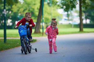 jongen en meisje met fiets foto