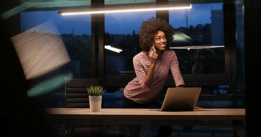 zwart zakenvrouw gebruik makend van een laptop in nacht opstarten kantoor foto