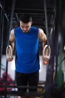 Mens werken uit Trekken ups met gymnastiek- ringen foto