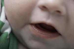 schattig weinig baby spelen met handen en glimlachen foto