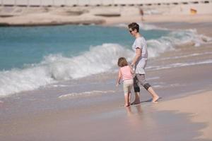 moeder en dochter rennen Aan de strand foto