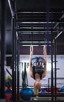 vrouw werken uit Aan gymnastiek- ringen foto