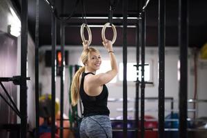 vrouw werken uit Aan gymnastiek- ringen foto