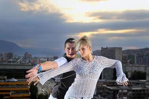 romantisch stedelijk paar dansen Aan top van bulding foto