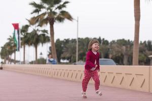 schattig weinig meisje Aan de promenade door de zee foto