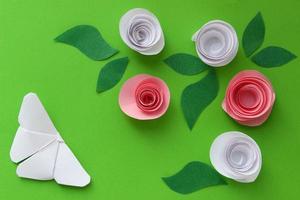 origami groen papier achtergrond met vlinder, bloemen en bladeren. origami samenstelling. papier ambacht foto