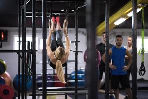 vrouw werken uit met persoonlijk trainer Aan gymnastiek- ringen foto