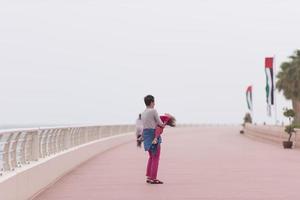 moeder en schattig weinig meisje Aan de promenade door de zee foto