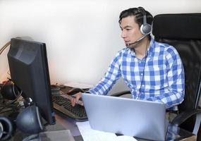 Mens werken van huis met een laptop Bij de bureau foto