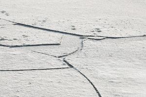 gebarsten ijs van bevroren meer, achtergrond van de ijstextuur foto