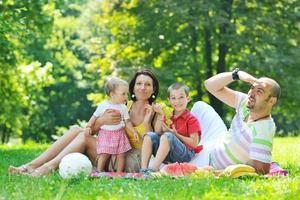 gelukkig jong koppel met hun kinderen veel plezier in het park foto