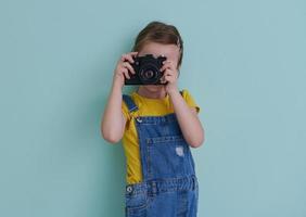 schattig weinig meisje nemen afbeelding gebruik makend van film foto camera