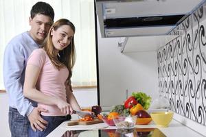 paar hebben pret en voorbereidingen treffen gezond voedsel in keuken foto