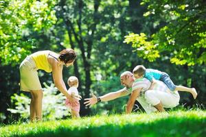 gelukkig jong koppel met hun kinderen veel plezier in het park foto