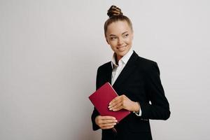 tevreden zakenvrouw in formele outfit met notitieboek foto