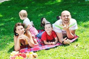 gelukkig jong koppel met hun kinderen veel plezier in het park foto