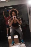 zwart vrouw atleet is het uitvoeren van doos springt Bij Sportschool foto