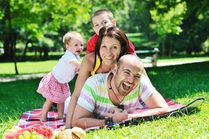 gelukkig jong koppel met hun kinderen veel plezier in het park foto