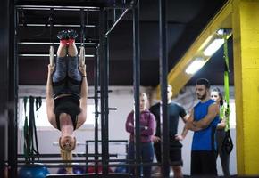 vrouw werken uit met persoonlijk trainer Aan gymnastiek- ringen foto