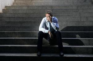 zakenman huilen verloren in depressie zittend op straat betonnen trappen foto