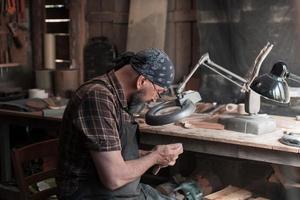 lepel meester in zijn werkplaats met houten producten en gereedschap foto