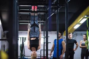 vrouw werken uit met persoonlijk trainer Aan gymnastiek- ringen foto