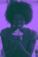 vrouw met afro kapsel aan het eten smakelijk pizza plak foto