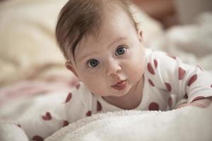 schattig weinig baby spelen met handen en glimlachen foto