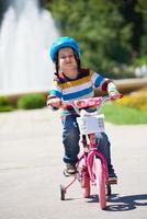 gelukkig jongen aan het leren naar rijden zijn eerste fiets foto