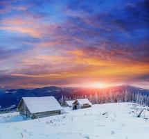 huisje in besneeuwde bergen met fantastische winterbomen foto