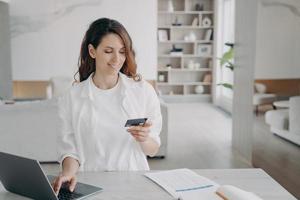 gelukkig spaans meisje houdt creditcard voor pc. e-commerce en financiële transacties. foto