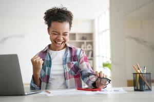 opgewonden biraciale studente viert overwinning, kreeg e-mail met goede scores. persoonlijke prestatie foto