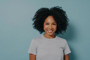 mooie lachende Afro-Amerikaanse vrouw met krullend zwart haar en stralende glimlach foto