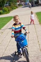 gelukkig jongen aan het leren naar rijden zijn eerste fiets foto