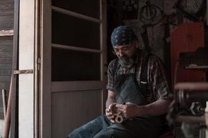 lepel ambacht meester in zijn werkplaats met handgemaakt houten producten en gereedschap werken foto