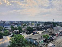 west Java, Indonesië Aan juli 2022. antenne visie van een sloppenwijk regeling Aan de noorden kant van Jakarta. deze regeling is gelegen Aan de rand van de rivier. foto