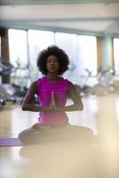 Afrikaanse Amerikaans vrouw oefening yoga in Sportschool foto