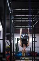 vrouw werken uit Aan gymnastiek- ringen foto