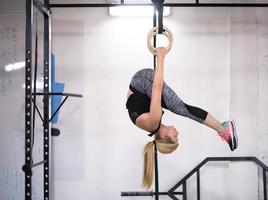 vrouw werken uit Aan gymnastiek- ringen foto