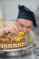 chef voorbereidingen treffen woestijn taart in de keuken foto