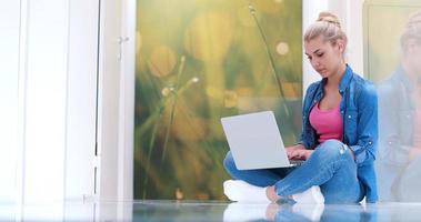 jonge vrouwen die laptopcomputer op de vloer gebruiken foto