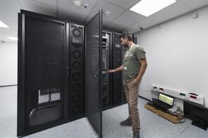 gegevens centrum ingenieur gebruik maken van toetsenbord Aan een supercomputer server kamer specialist faciliteit met mannetje systeem beheerder foto