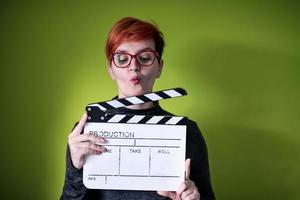 vrouw Holding film klepel tegen groen achtergrond foto