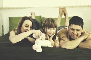 gelukkig familie ontspannende in bed foto