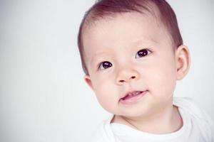 schattig Aziatisch baby lachend Aan wit achtergrond, studio schot foto