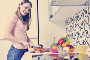 gelukkig jong vrouw met appel in keuken foto