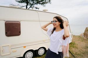 mooi, jong meisje poseren Aan een wild strand matroos Bij de busje foto