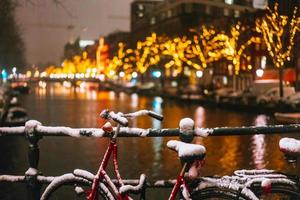 fietsen geparkeerd langs een brug over- de grachten van Amsterdam foto