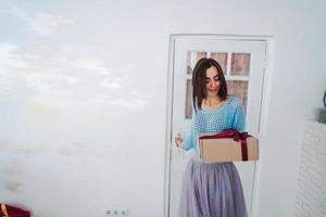 vrouw Holding Kerstmis geschenk doos in haar handen foto