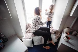 moeder en haar dochter meisje Speel in kinderen kamer foto